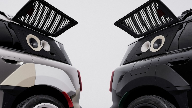 Bližnji posnetek zadnjih četrtinskih oken obeh avtomobilov, ki prikazujeta njuna zvočnika pred belim ozadjem