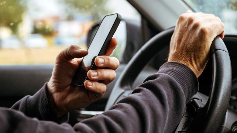 Človek pošilja sporočila med vožnjo