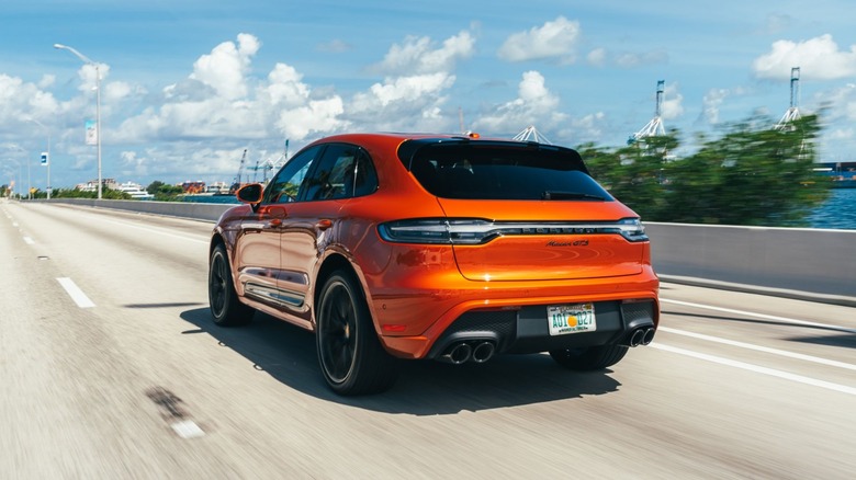 Oranžni Porsche Macan GTS na avtocesti.