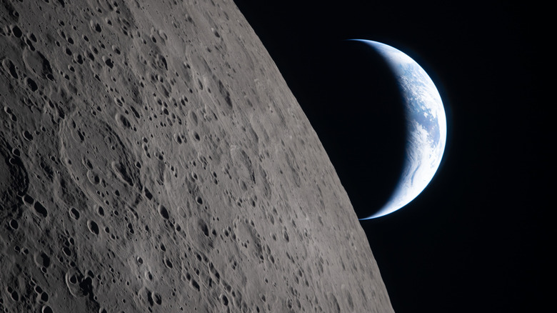 Fotografija iz misije Artemis II, ki prikazuje Luno v ospredju in Zemljo v polmesecu v ozadju