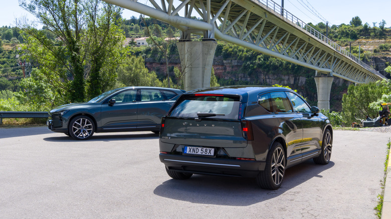 Par volvov EX60 letnik 2027, parkiranih v senci mostu