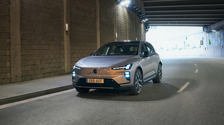 Srebrni Volvo EX60 letnik 2027 med vožnjo skozi tunel