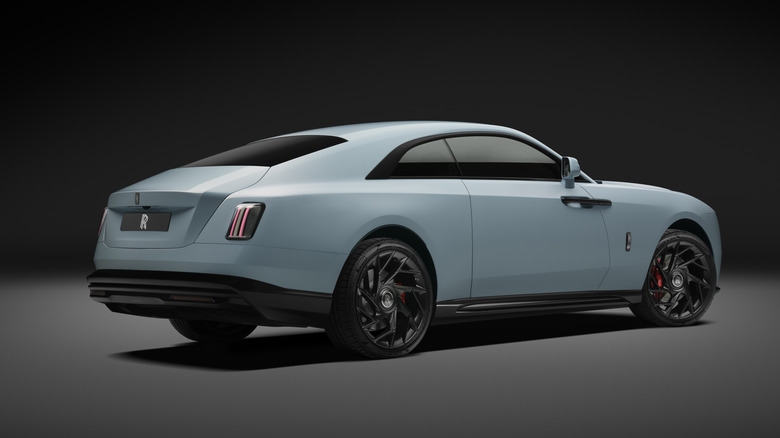 Pogled od zadaj 3/4 modrega Rolls-Royce Spectre Series II Black Badge