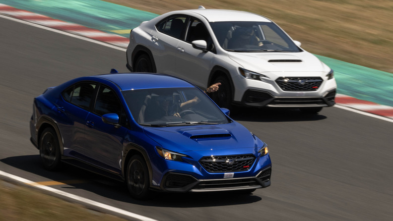 Posnetek od zgoraj modrega WRX-a, ki kaže belega WRX-a mimo na dirkališču