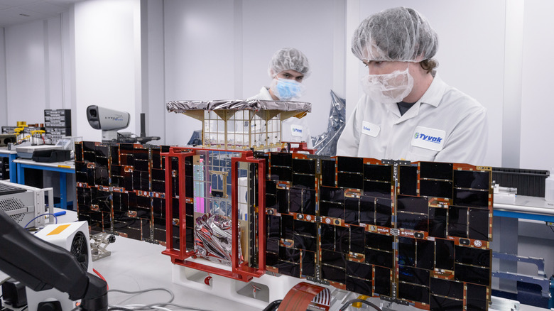 Dylan Schmidt, vodja integracije in testiranja sklopov CAPSTONE, desno, in Lachlan Moore, inženir sistemske integracije, levo, nameščata sončne celice na vesoljsko plovilo CAPSTONE 01 pri podjetju Tyvak Nano-Satellite Systems, Inc., v Irvinu v Kaliforniji.