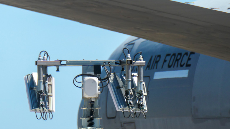 Prednji trup in oznake letala McDonnell Douglas KC-10A Extender ameriških zračnih sil, registrska številka 84-0191, parkiranega na letališču Kingsford-Smith v Sydneyju. V ospredju sta prenosni komunikacijski stolp in eden od horizontalnih stabilizatorjev letala.