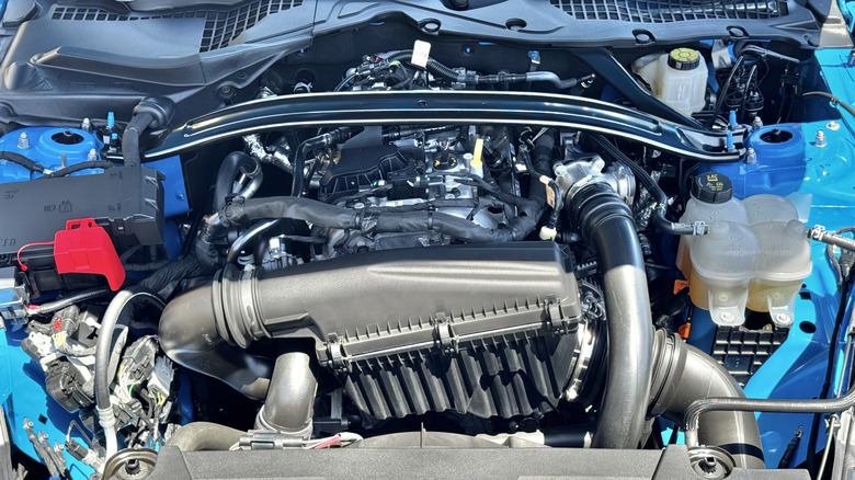 Fotografija pod pokrovom modrega Mustanga Ecoboost, ki prikazuje njegov 2,3-litrski štirivaljnik EcoBoost