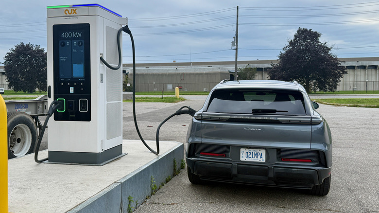 Pogled od zadaj na Porsche Cayenne Electric, ki se polni na postaji s 400 kW.