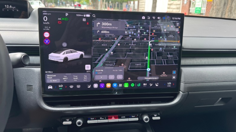 Fotografija zaslona infotainmenta Pleos Connect in vrstice gumbov pod njim