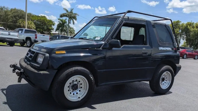 Črn Chevrolet Tracker iz leta 1998 na parkirišču, fotografiran pod rahlo nagnjenim kotom.