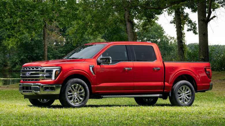 2027 Ford F-150 Lariat bočni profil, parkiran na travi pred drevesi