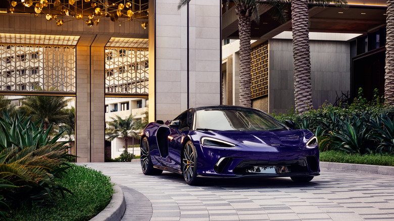 Vijolični McLaren GTS, parkiran pred luksuznim hotelom.