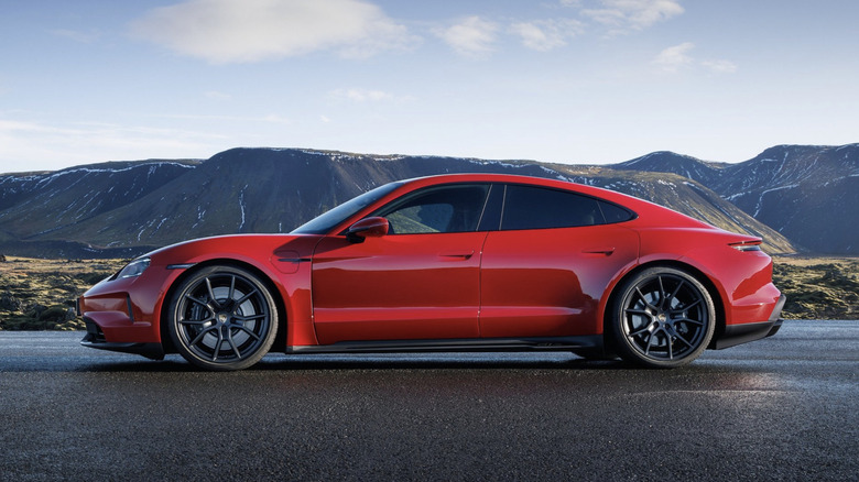 Rdeči porsche parkiran na mokri cesti v gorah