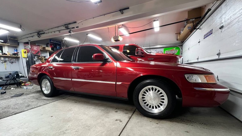 Slika sovoznikove strani Mercuryja Grand Marquis iz leta 1999, parkiranega v garaži