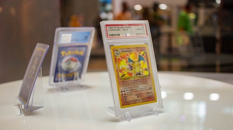 Kartica prve generacije Charizard Pokemon, zaprta in razstavljena na mizi na dogodku Comic Con v New Yorku 2021.