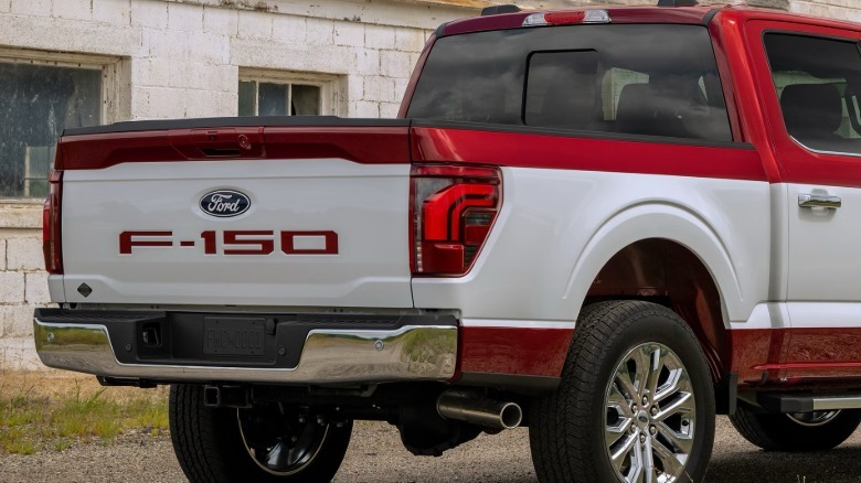 Zadnji tričetrtinski posnetek postelje rdečega F-150 z belo črto od blizu