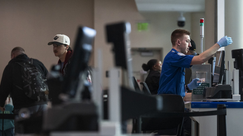 MINNEAPOLIS, MINNESOTA – 23. MAREC: Agent TSA pregleda potnike na letališču Minneapolis-St. Terminal 2 mednarodnega letališča Paul 23. marca 2026 v Minneapolisu v Minnesoti. Motnje pri potovanju se nadaljujejo, saj na stotine agentov TSA odpušča ali dela brez plačila med delno zaustavitvijo vlade. Ameriški predsednik Donald Trump je dejal, da bodo agenti ICE napoteni na ameriška letališča v ponedeljek, za to pa bo zadolžen obmejni car Tom Homan. (Fotografija: Stephen Maturen/Getty Images)