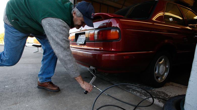 SAN RAFAEL, CA - 12. DECEMBRA: Alex Gromov postavi sondo v izpušno cev avtomobila, medtem ko opravlja preverjanje smoga na Marinwood Smog Check 12. decembra 2007 v San Rafaelu v Kaliforniji. Zvezni okrožni sodnik Anthony W. Ishii je podprl kalifornijski zakon iz leta 2002, ki ureja emisije toplogrednih plinov iz avtomobilov in tovornjakov, kar bi prisililo proizvajalce avtomobilov, da povečajo povprečno porabo goriva svojih voznih parkov za približno 30 odstotkov do leta 2016. Podoben predlog zakona, ki je v obravnavi v kongresu, bi zahteval 40-odstotno povečanje prevoženih kilometrov do leta 2020. (Foto: Justin Sullivan/Getty Images)
