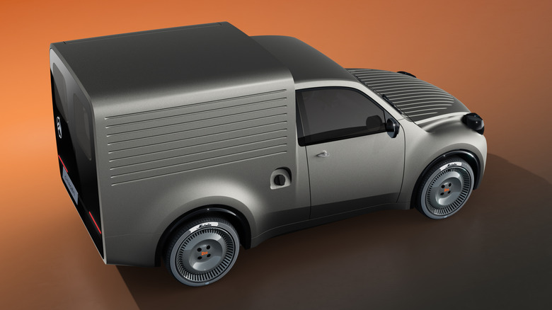 Pogled od zadaj 3/4 srebrnega koncepta Citroën 2CV Fourgonnette na oranžnem ozadju
