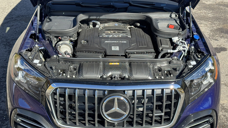 Pogled pod pokrov temno modrega novinarskega avtomobila GLS, ki sem ga vozil in vrtel njegov AMG V8, ko sem bil parkiran na asfaltu